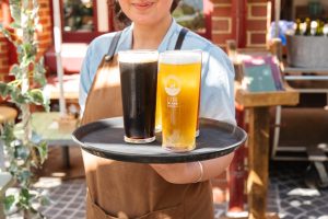 A server presenting drinks at The Island at Elizabeth Quay, a top choice for corporate Christmas functions in Perth