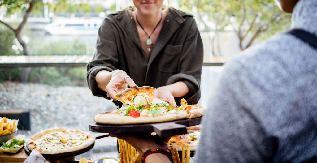 Sharing gourmet pizzas at one of the top corporate function venues in Perth, The Island at Elizabeth Quay